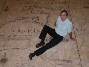 David Woodward sitting on a marble replica of the Tasman Map of 1644 in the entrance hall of The State Library of New South Wales, Sydney, Australia.