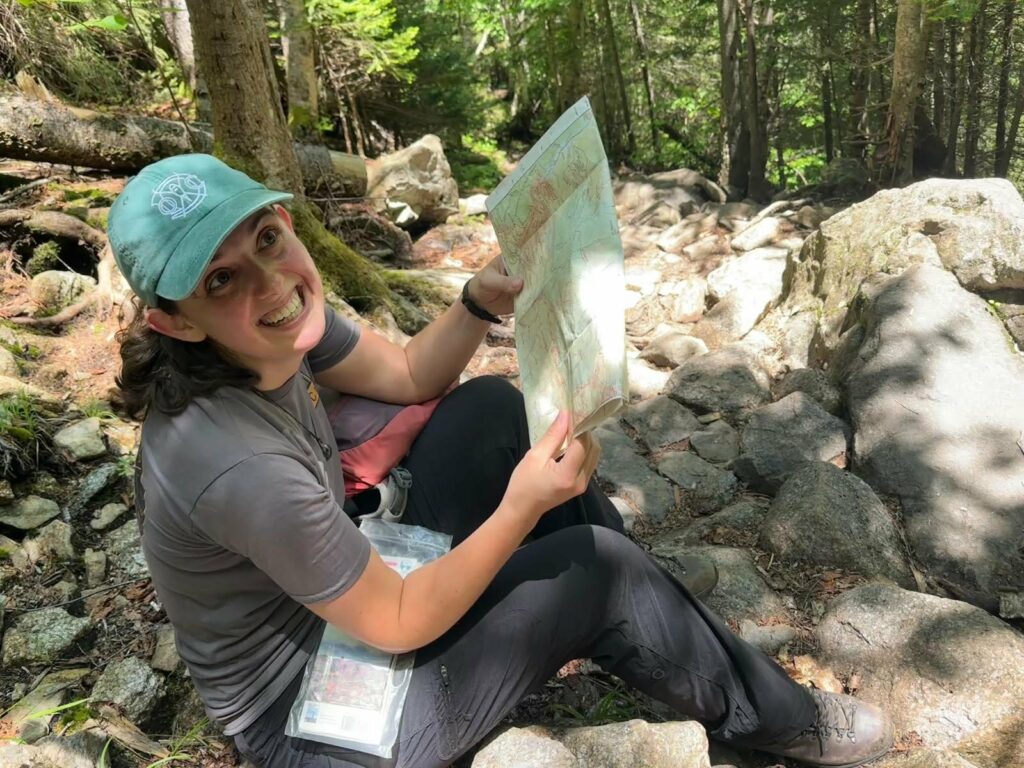 Maddy Kroot in a forest holding a map