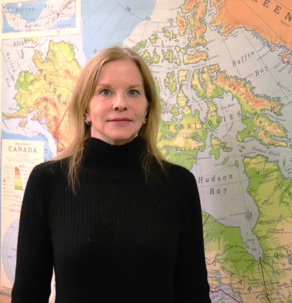 Sarah Moore stands in front of a map